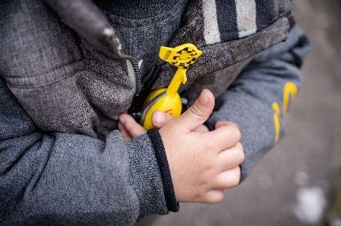 Ein Kind hält einen gelben Spielzeughubschrauber fest ins einen Händen.